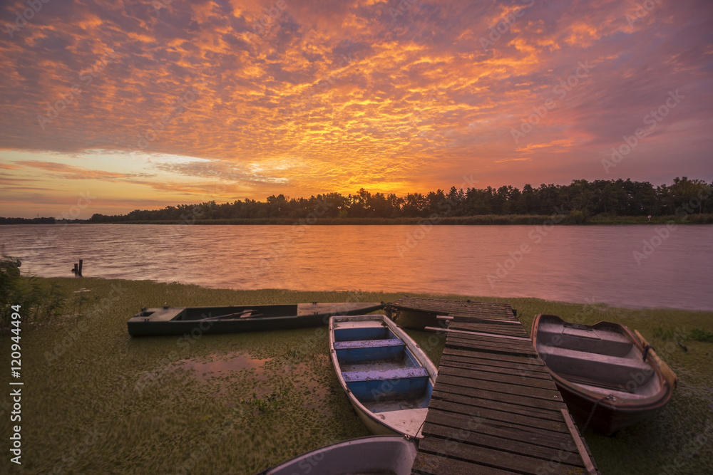 Obraz premium fishing harbor in the beautiful scenery of dynamic sunrise