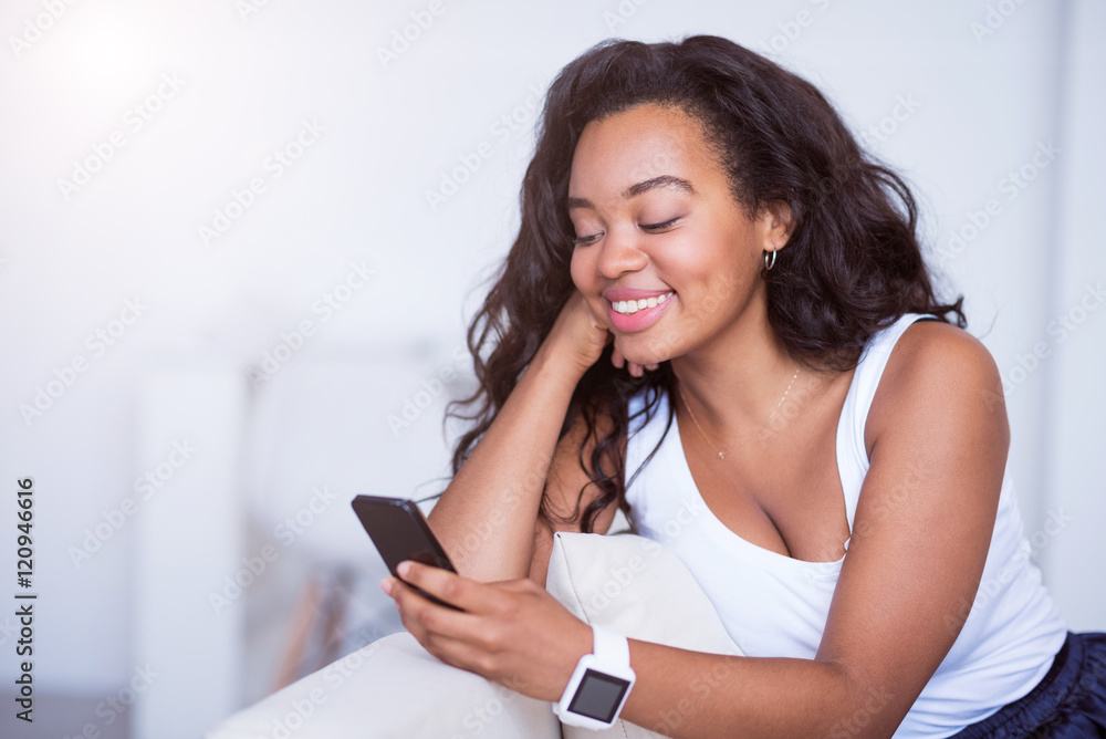 Fototapeta premium Positive smiling woman using cell phone