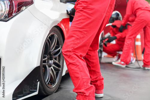 Auto mechanic changing racing car wheel