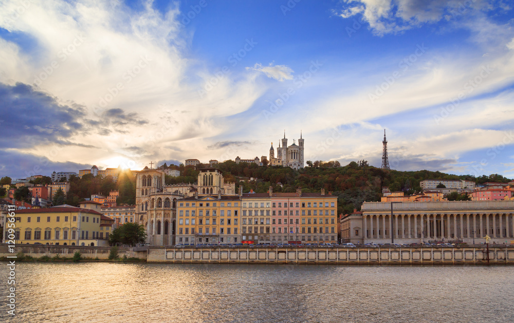 Colorful sunset at Vieux Lyon and Fourviere Basilica seen from the riverbank of the Saone, Lyon.