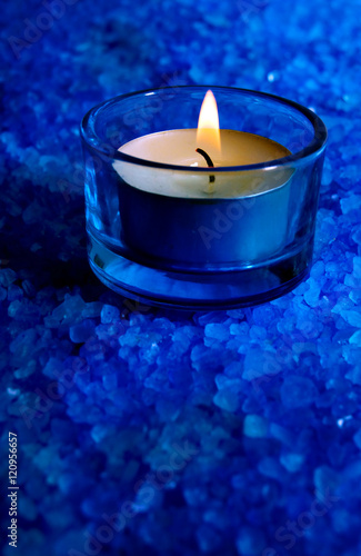 Wellness and spiritual symbol - blue candle with crystals and copy space 