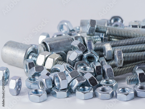 Bolts and screws on a white background. Bolts and screws used in construction. Tightening around the neck. Bolts and screws are descendants of mainly made of fine steel. Bolts and screws in isolate.