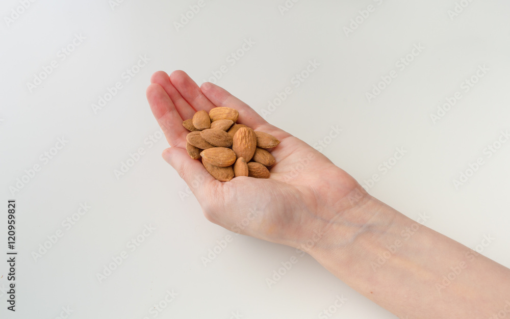 Woman Holding Almonds in Her Hand on a White Background Woman Holding Almonds in Her Hand on a White Background