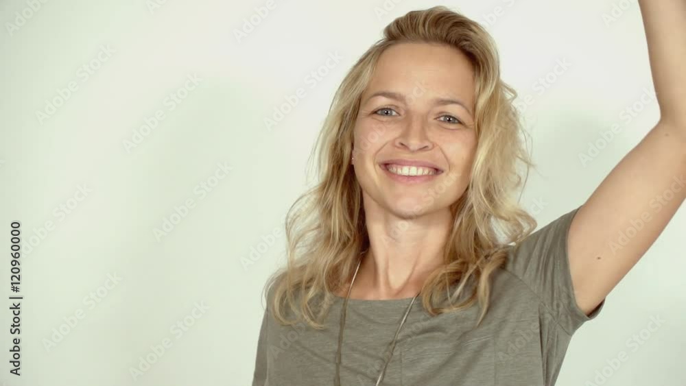 junge, hübsche Frau tanzt im Studio vor weißer Wand