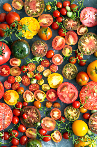 A lot of fresh and ripe tomatoes of different sizes and colours  – top view