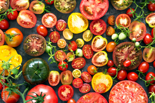 A lot of fresh and ripe tomatoes of different sizes and colours  – top view