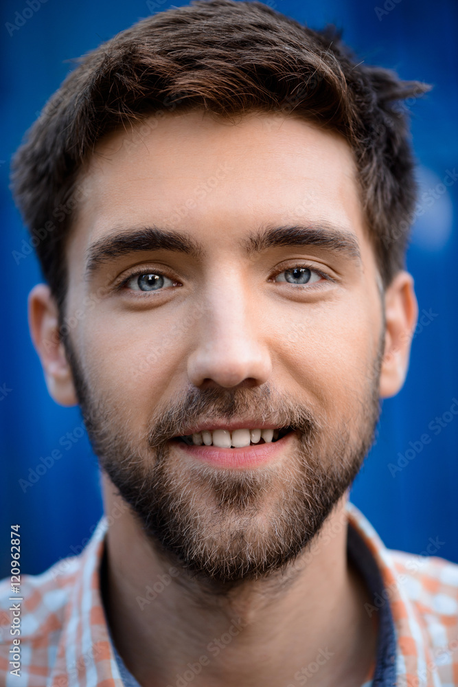 Obraz premium Close up portrait of handsome man smiling over blue background.