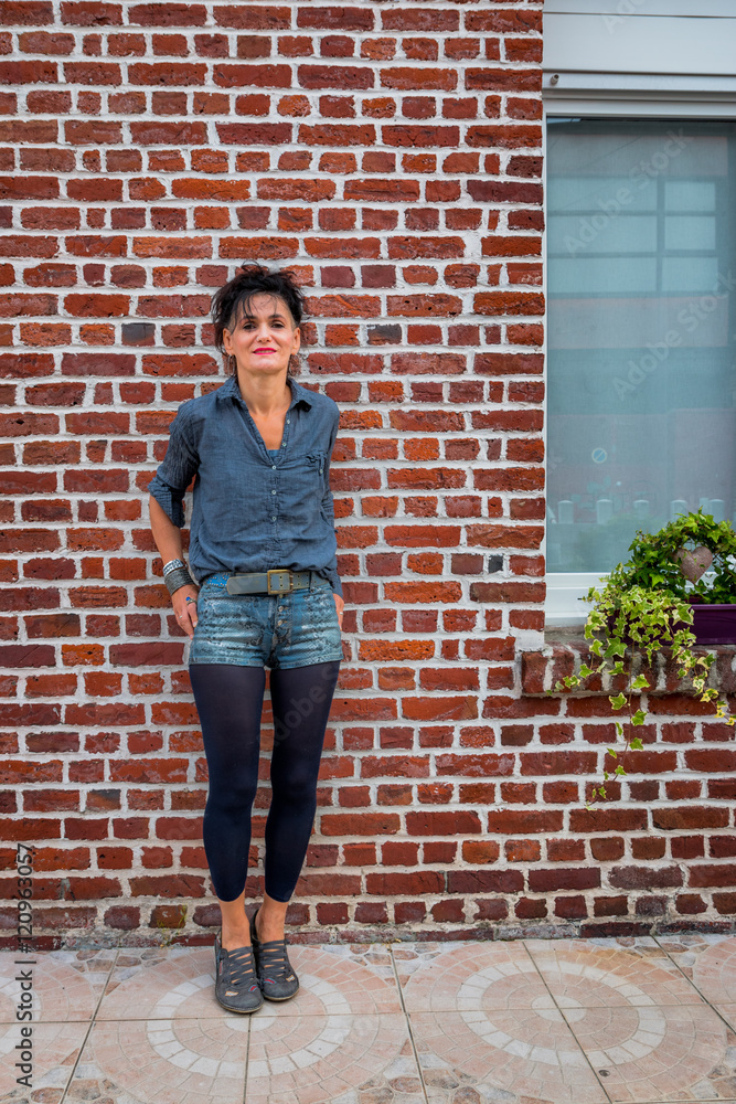 Femme devant une maison de briques rouges Femme devant une maison de briques rouges