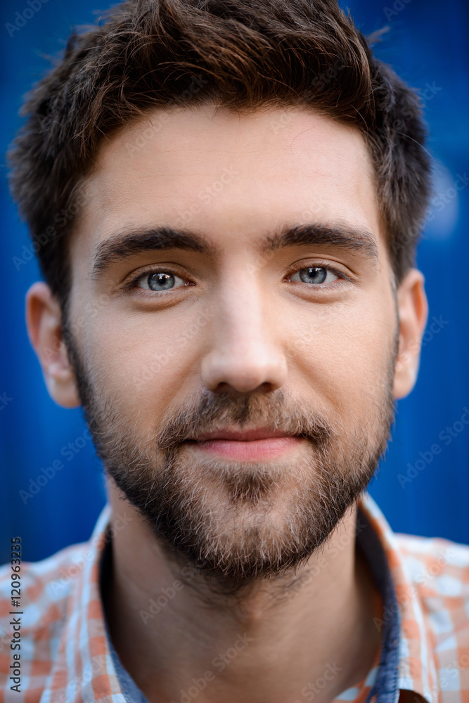 Obraz premium Close up portrait of handsome man smiling over blue background.