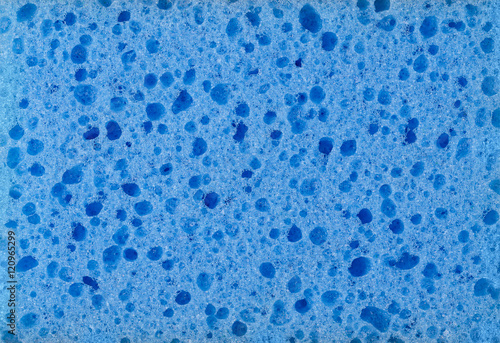 Blue urethane sponge surface macro photo. Synthetic tool and cleaning aid consisting of soft, porous material, made from foamed plastic polymers with visible pores and openings. Macro photo close up.