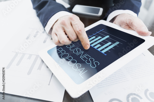 Close-up of modern businessman presenting business proposal at meeting at office from tablet computer