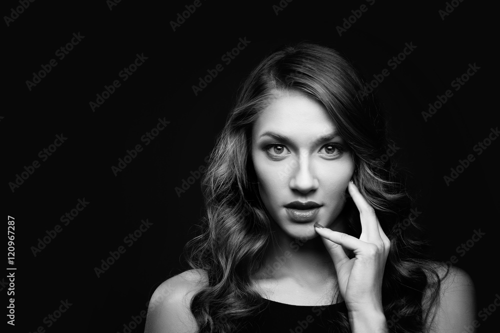 Beautiful young woman with long wavy hair on black background. Black and white Beautiful young woman with long wavy hair on black background. Black and white