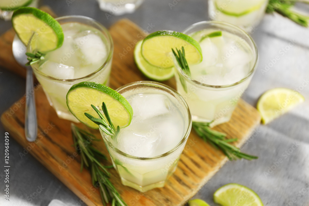 Cold fresh cocktails with lime on cutting board Cold fresh cocktails with lime on cutting board