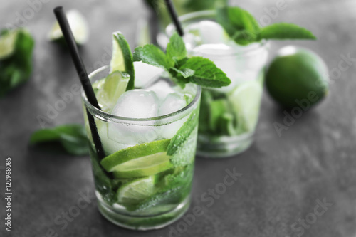 Cold fresh cocktails with lime on grey background