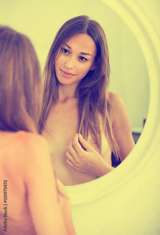 Naked woman looking at mirror - a Royalty Free Stock Photo from Photocase