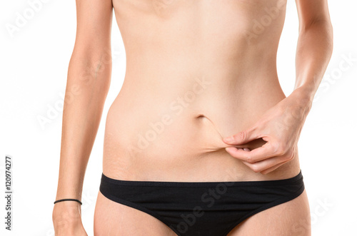 Slim woman pinching the skin on her stomach