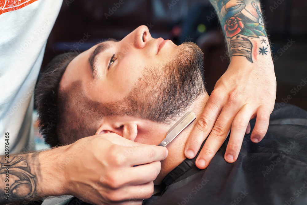 Young man having beard shaven Young man having beard shaven