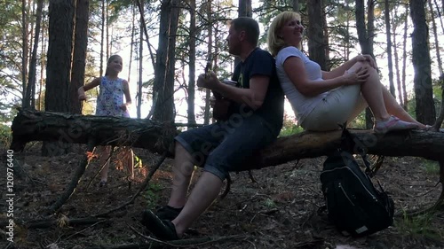The family in the woods playing guitar