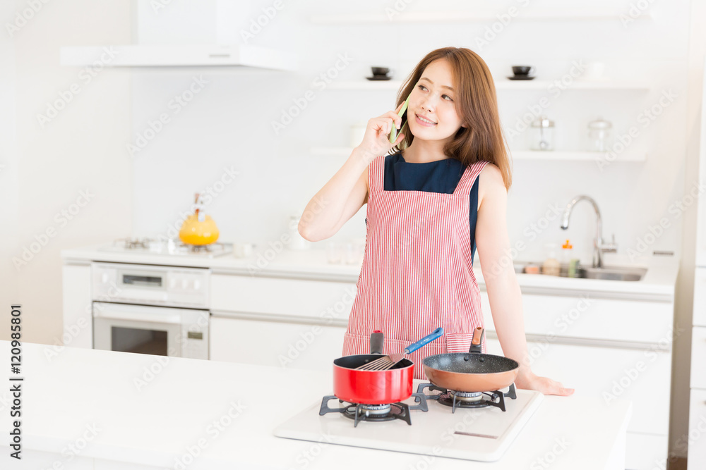 キッチンで電話をする女性 キッチンで電話をする女性