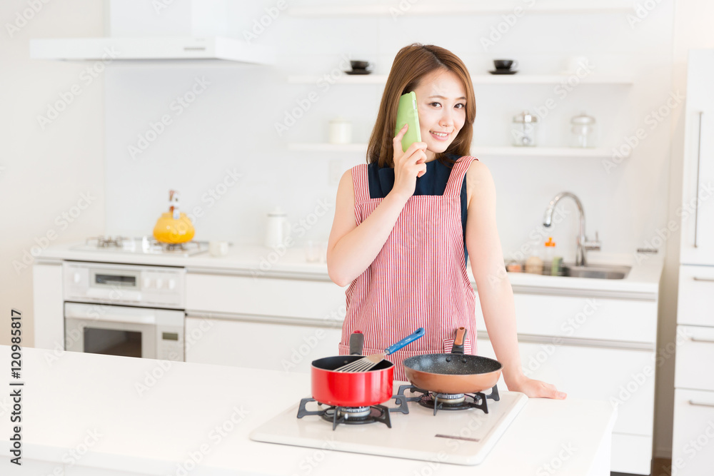 キッチンで電話をする女性 キッチンで電話をする女性