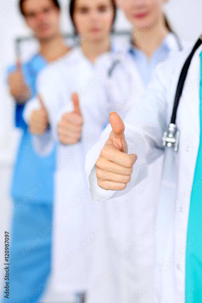 Group of doctors showing OK or approval sign with thumb up. High level and quality medical service, best treatment and patient care concept Group of doctors showing OK or approval sign with thumb up. High level and quality medical service, best treatment and patient care concept
