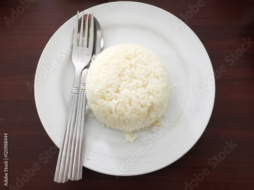 Rice on white dish on wooden background