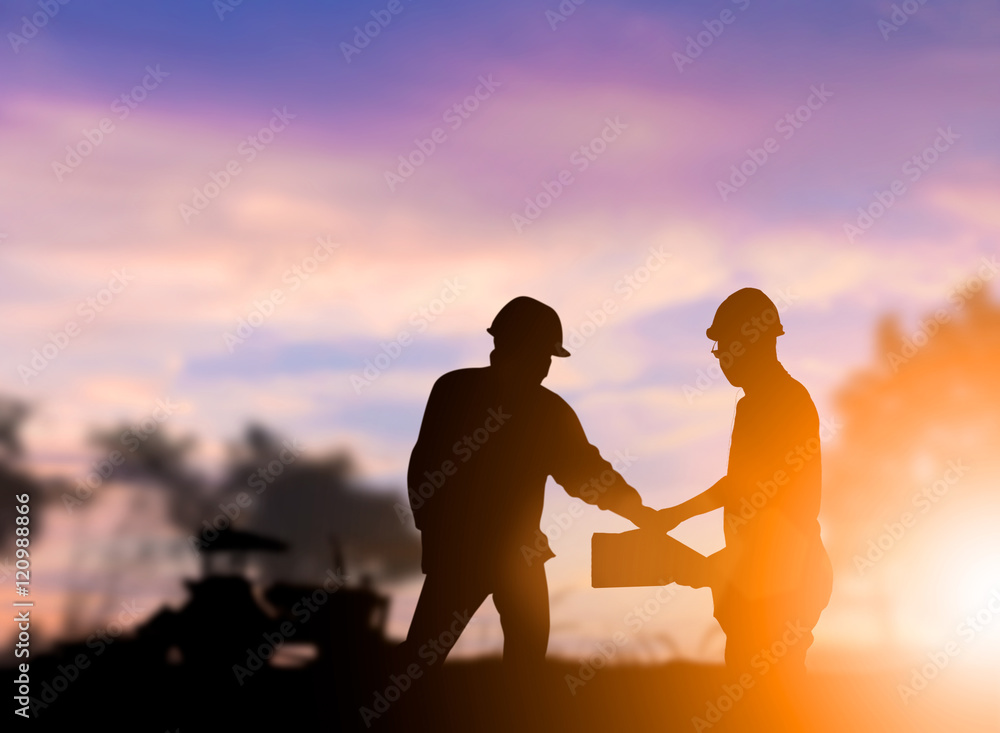Silhouette engineer construction industry stands shake hands wit