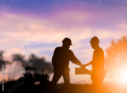 Silhouette engineer construction industry stands shake hands wit © Yuttana Studio