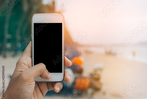 mobile smartphone in man's hands on the beach