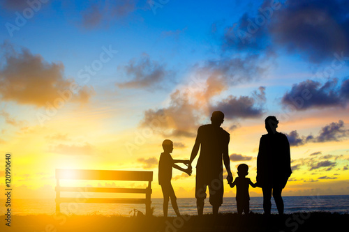 Silhouette family mother  father and young son holding hands  ta
