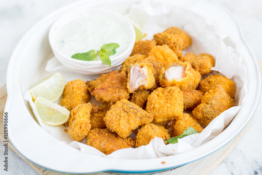 Tortilla crusted baked fish bites on white bowl Tortilla crusted baked fish bites on white bowl