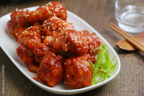 Korean fried chicken on white plate on wooden table