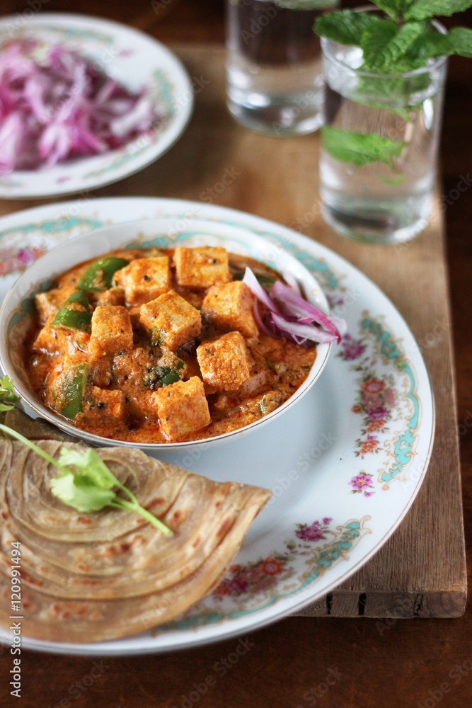 Tofu and capsicum curry recipe on white plate on wooden table