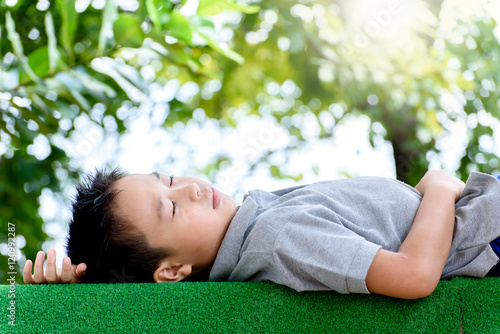 Boy lay on the green lawn