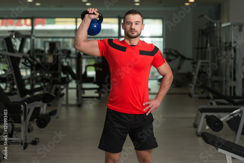Personal Trainer Exercising With Kettle-bell © Jale Ibrak