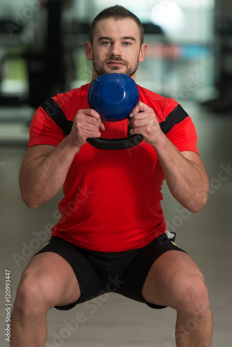 Personal Trainer Exercising With Kettle-bell
