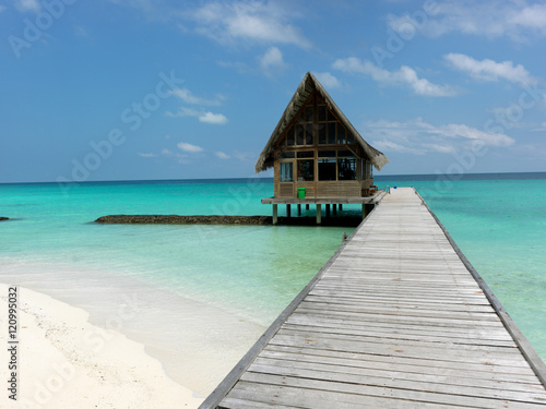 Maldives. A footpath goes to the bungalow, which is in the ocean. Sunny day. © ustiv