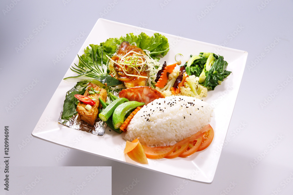 Braised pork rice, braised fish meal with vegetable on white pla Braised pork rice, braised fish meal with vegetable on white pla