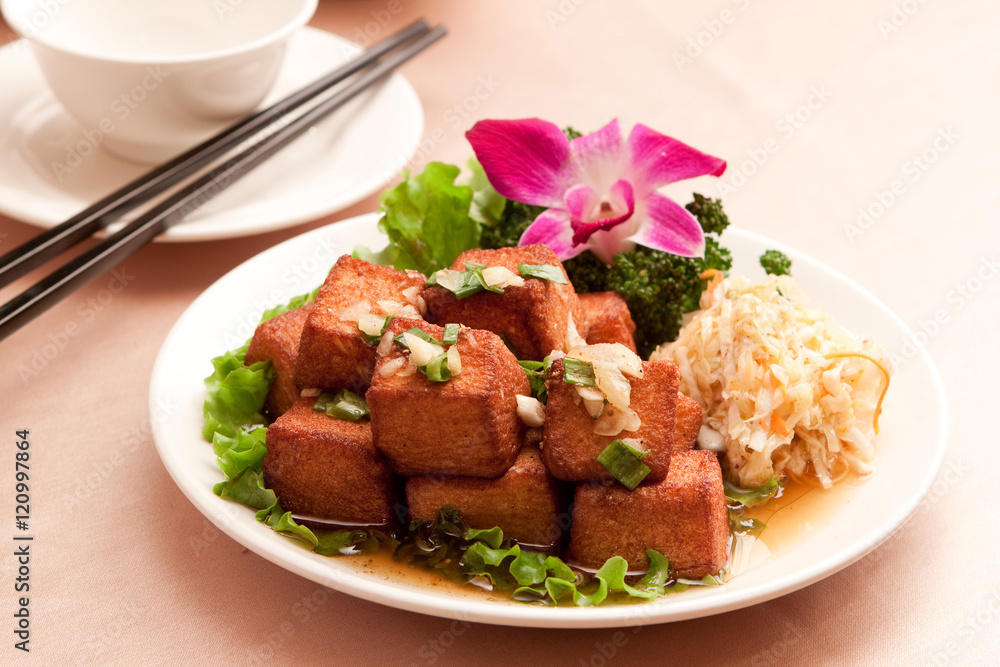 Fried tofu with lettuce and salad on white plate