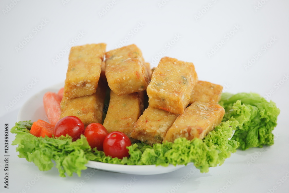 Fried tofu with lettuce, tomatoes and carrot on white plate Fried tofu with lettuce, tomatoes and carrot on white plate