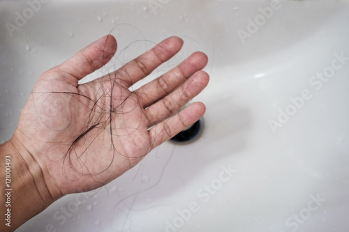 Photography Close-up a man hand with loss hair, after taking shower, concepts of loosing hai