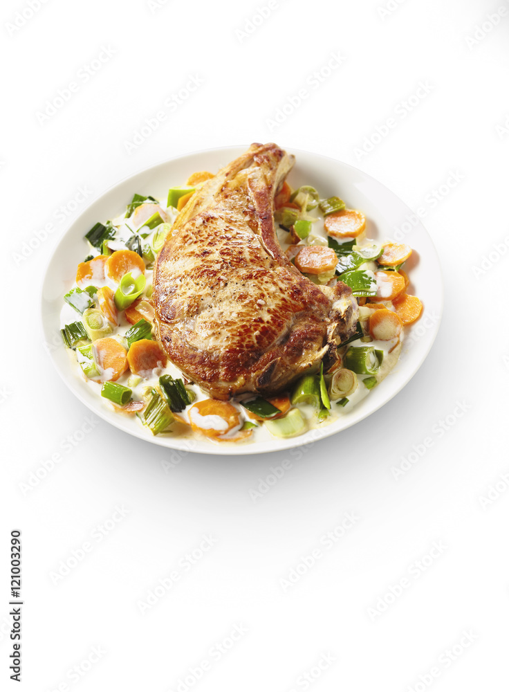 Veal chop with vegetable cream on white plate in restaurant Veal chop with vegetable cream on white plate in restaurant