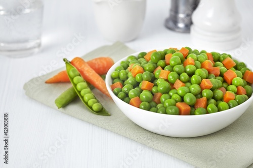 Fresh bowl of green beans and cubed carrots on white background