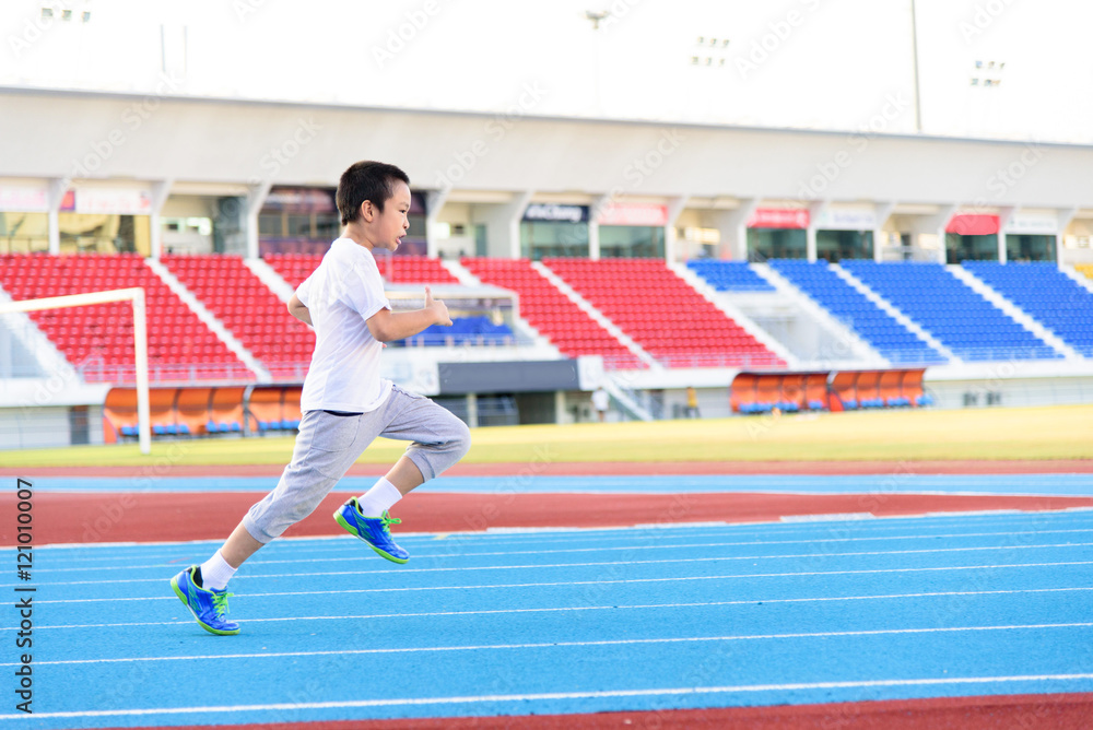 Fototapeta premium Boy runnin on blue track