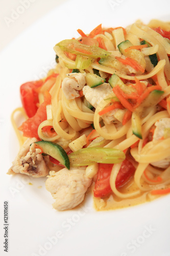 Linguine with chicken breast and vegetables on white plate