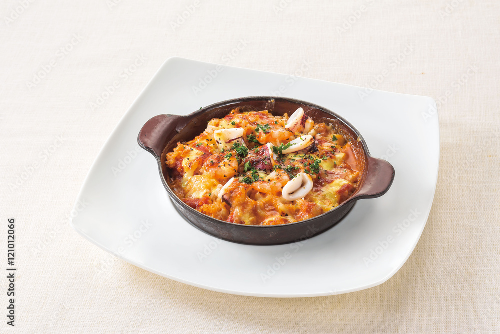 Tomato cream Doria of shrimp and squid on white plate background Tomato cream Doria of shrimp and squid on white plate background