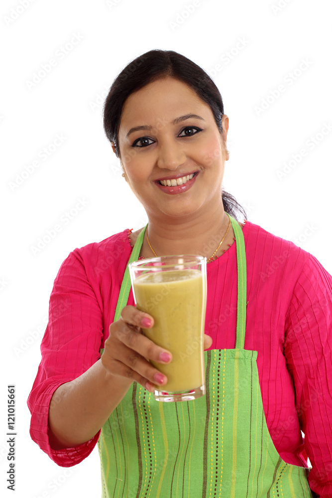 Happy female chef holding glass of avocado smoothie against whit Happy female chef holding glass of avocado smoothie against whit