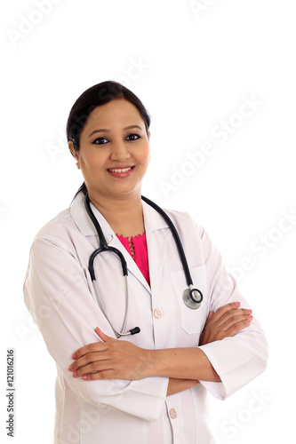 Young female doctor with arms crossed against white background