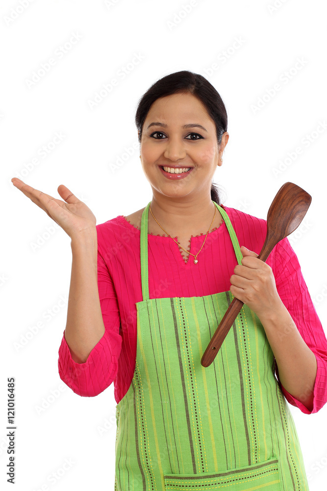 Happy young woman holding kitchen utensil against white backgrou Happy young woman holding kitchen utensil against white backgrou