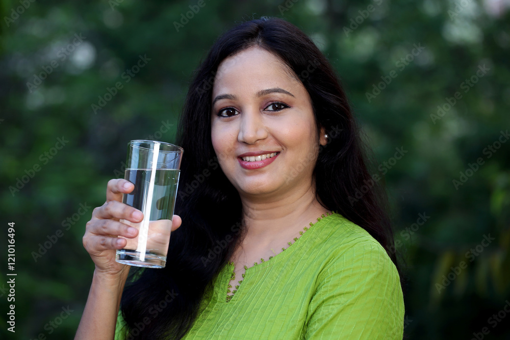 Smiling young woman drinking water at outdoors Smiling young woman drinking water at outdoors
